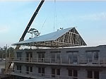 Roof sections are lifted and secured in place